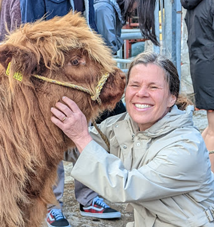 Dr. Monika Oli gets a kiss from a Highland cow.