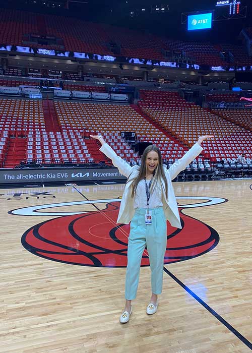 UF Online sport management and tourism, hospitality and event management student Kalena Miles stands in the Miami Heat basketball arena.