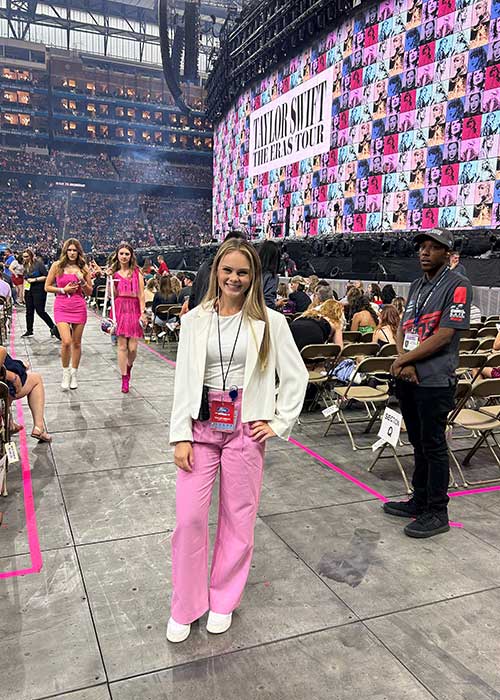 UF Online sport management and tourism, hospitality and event management student Kalena Miles stands in front of the stage at a Taylor Swift concert at Ford Field in Detroit.