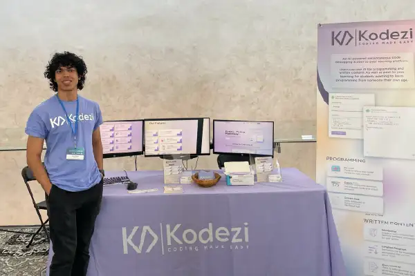 UF Online business student and Kodezi co-founder Ishraq Khan stands at a Kodezi branded booth during a trade show.